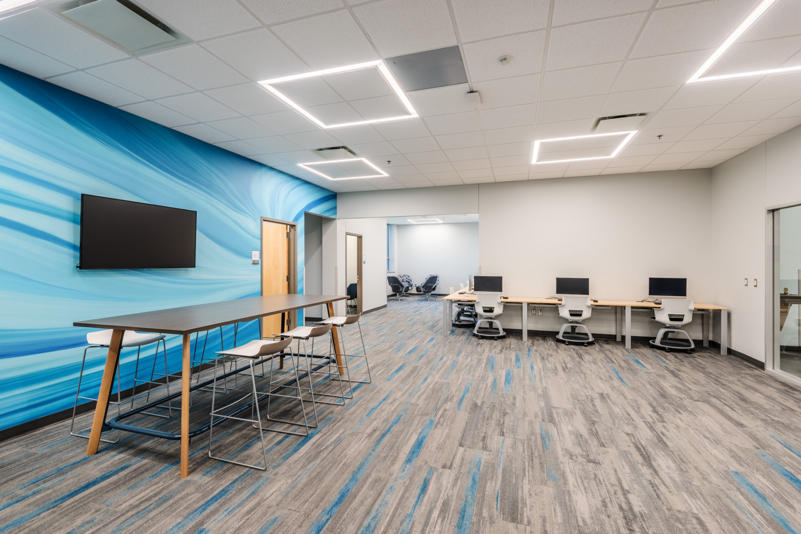 College of the Albemarle Dare County Campus Study Area with Computers, Desks, a Mounted TV, and a Blue Accent Wall
