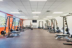 Fuquay-Varina High School Weight Room with Free Weights and a Mounted TV