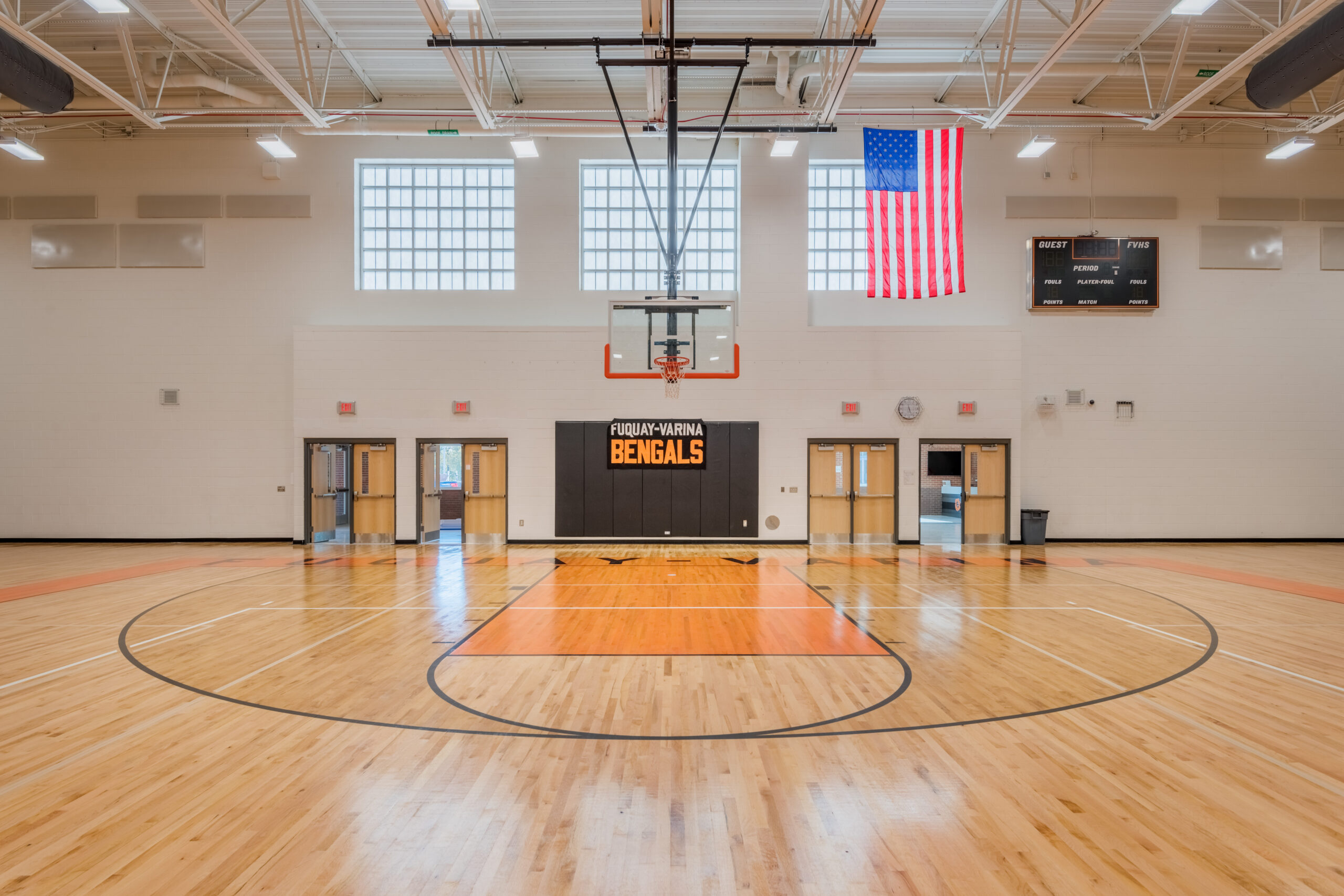 Fuquay-Varina High School Gymnasium with Basketball Court, Safety Wall Pads, and Orange Floor Paint