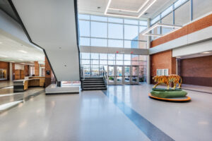 Fuquay-Varina High School Two-Story Lobby with Floor to Ceiling Windows and a Floating Staircase